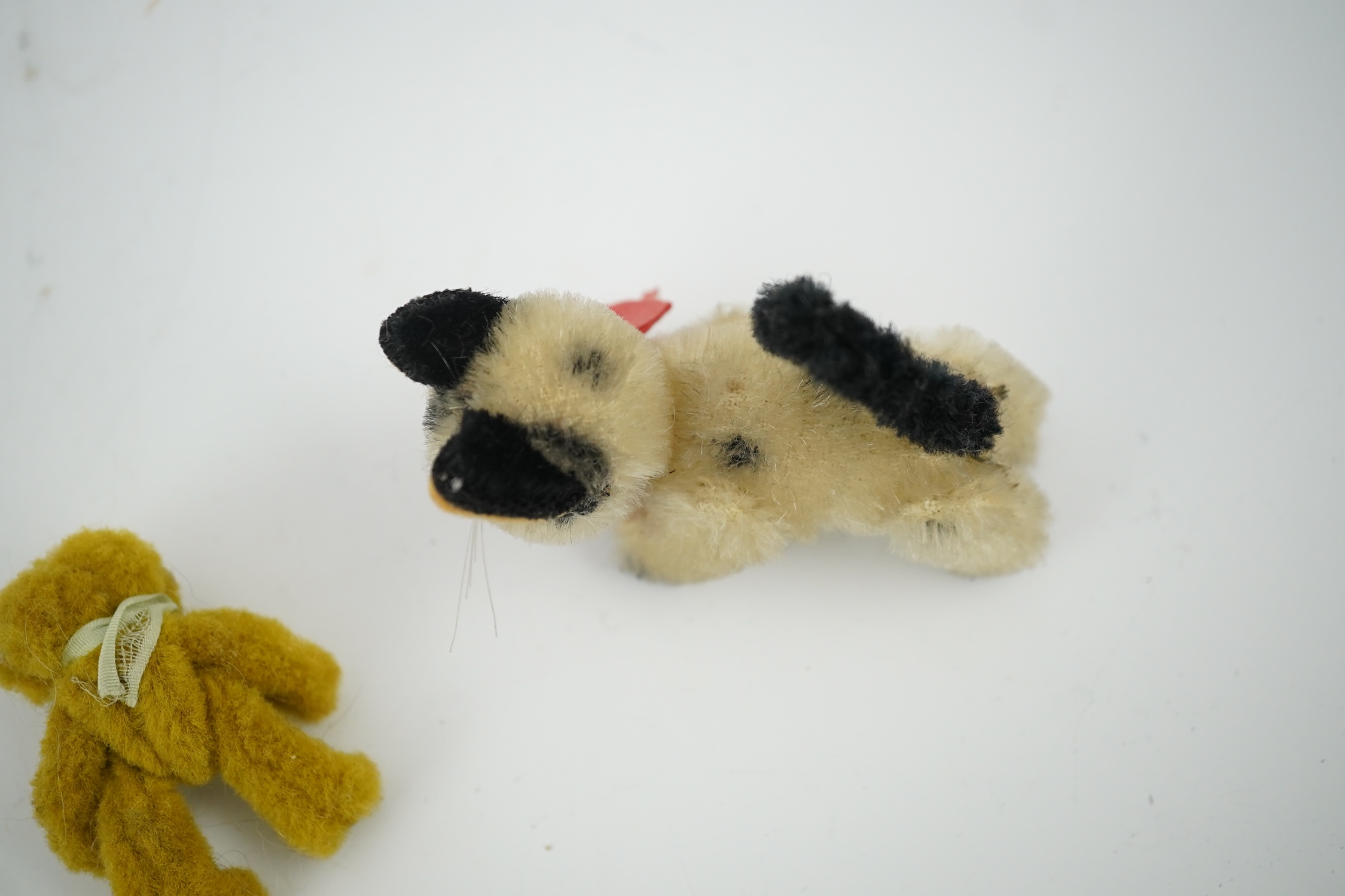 A small Schuco cat with revolving head and a tiny jointed teddy bear, largest 9cm in length. Condition - fair to good